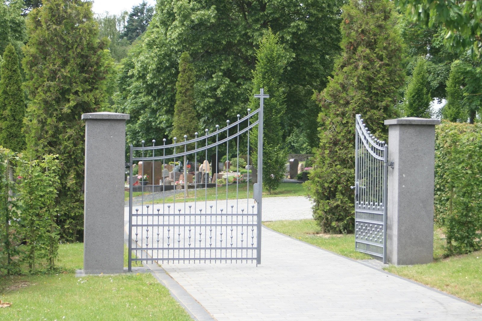 Zweiflügeliges Metalltor zwischen gemauerten Pfeilern